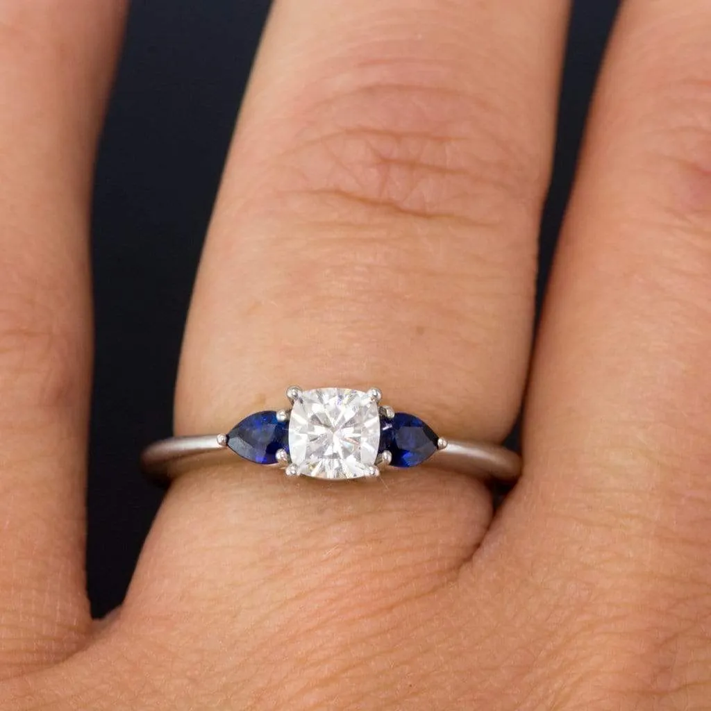 Tressa- Three Stone Engagement Ring, Prong set Cushion Moissanite & Pear Blue Sapphire Accents