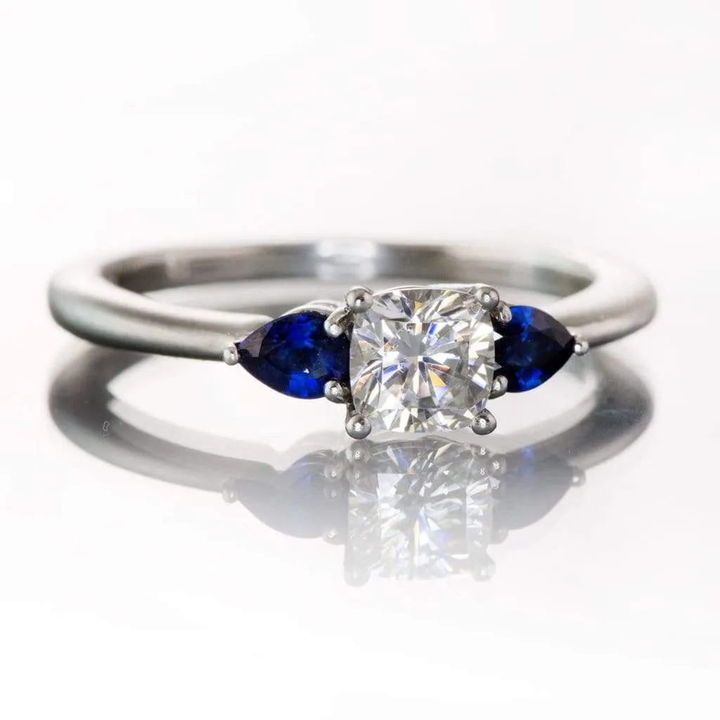 Tressa- Three Stone Engagement Ring, Prong set Cushion Moissanite & Pear Blue Sapphire Accents