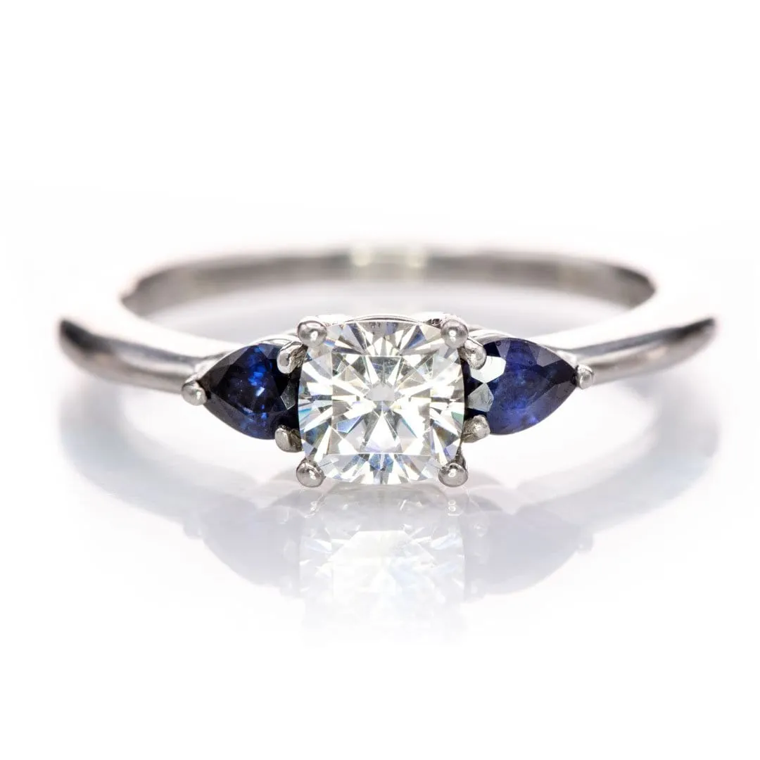 Tressa- Three Stone Engagement Ring, Prong set Cushion Moissanite & Pear Blue Sapphire Accents