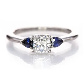 Tressa- Three Stone Engagement Ring, Prong set Cushion Moissanite & Pear Blue Sapphire Accents