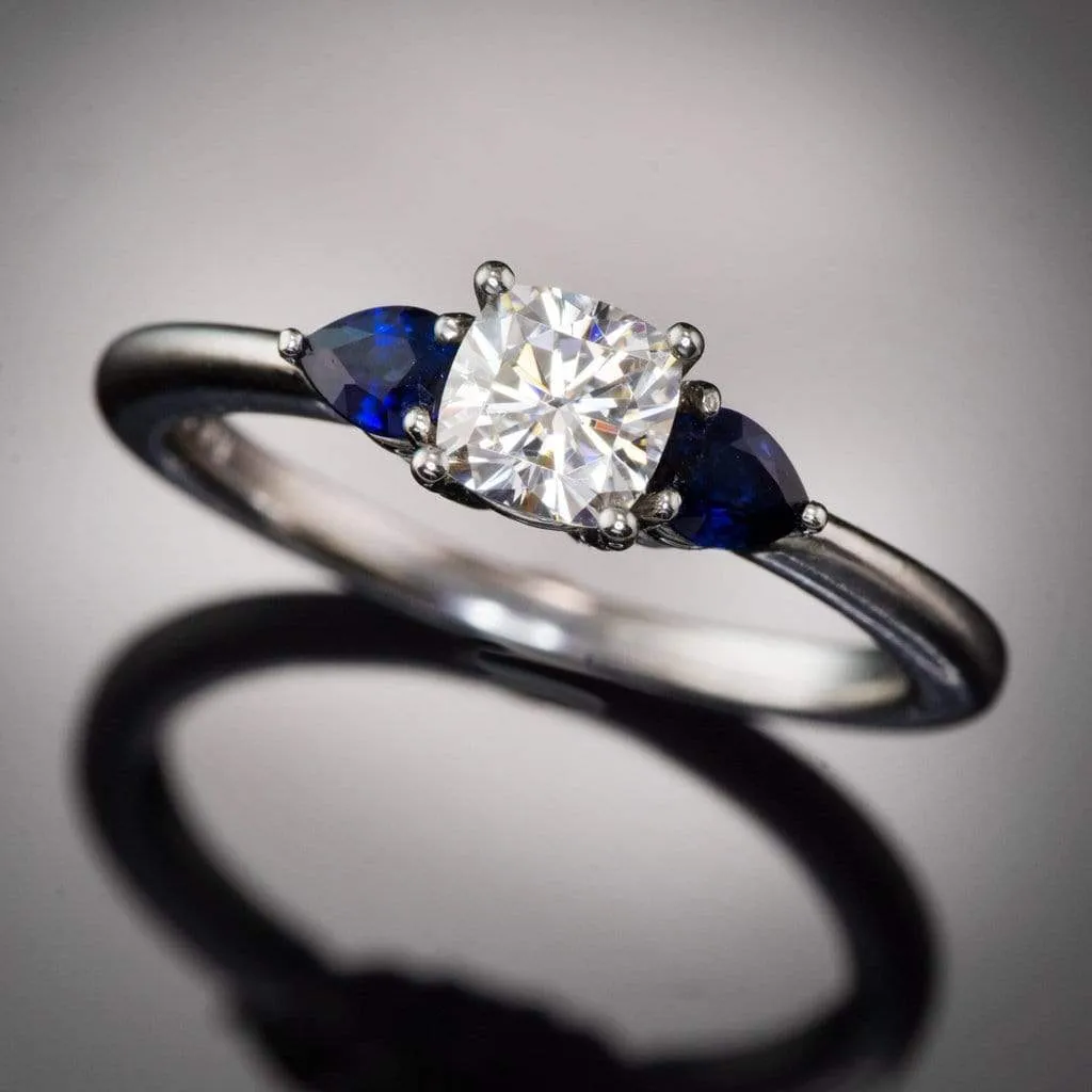 Tressa- Three Stone Engagement Ring, Prong set Cushion Moissanite & Pear Blue Sapphire Accents