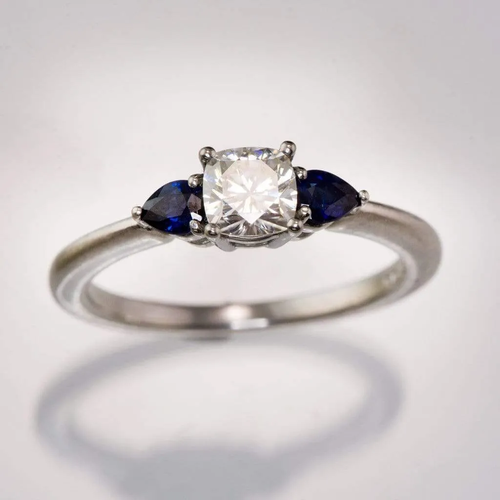 Tressa- Three Stone Engagement Ring, Prong set Cushion Moissanite & Pear Blue Sapphire Accents