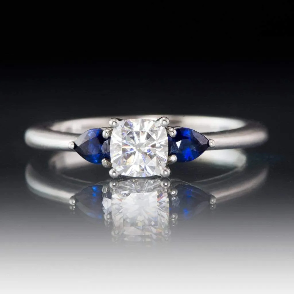 Tressa- Three Stone Engagement Ring, Prong set Cushion Moissanite & Pear Blue Sapphire Accents