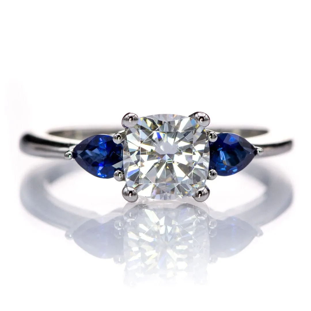 Tressa- Three Stone Engagement Ring, Prong set Cushion Moissanite & Pear Blue Sapphire Accents